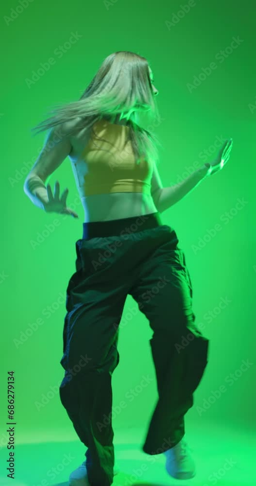Lady clubbing at disco party with colorful flashes of light on dark background. Girl dancing hip hop slow motion vertical video. Lady clubbing at disco party with colorful flashes of light on dark background. Girl dancing hip hop slow motion vertical video.