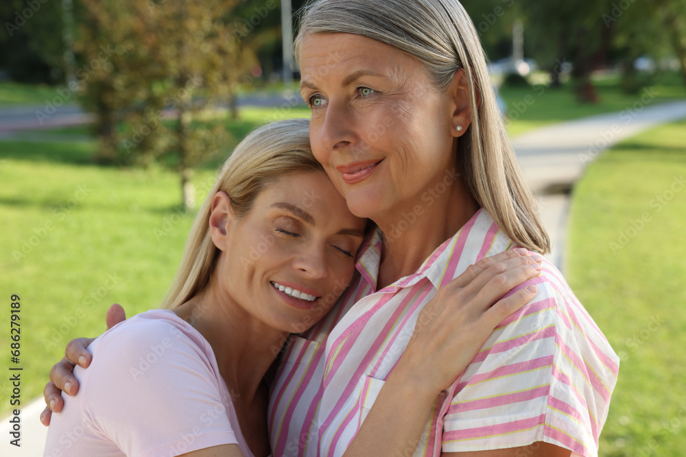 Family portrait of mother and daughter hugging in park Family portrait of mother and daughter hugging in park