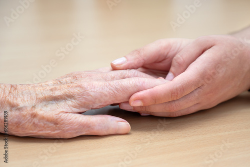 Hands of a young and old woman are holding together. High quality photo © herraez
