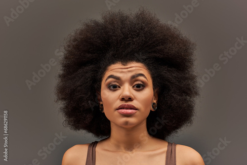 young african american woman in pastel underwear looking surprisedly at camera, fashion concept
