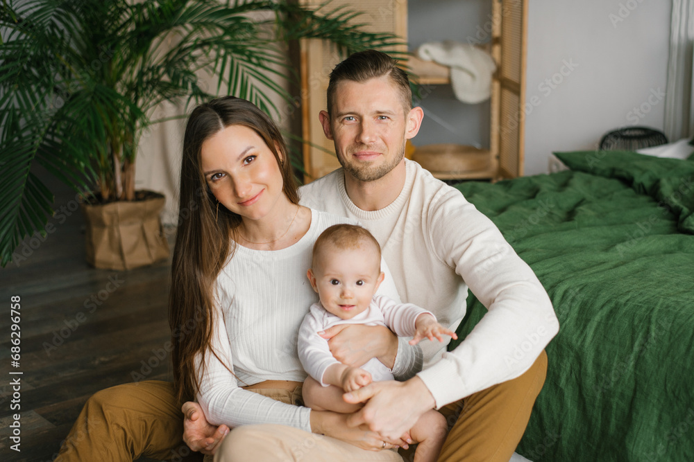 Portrait of a beautiful young family with a baby at home