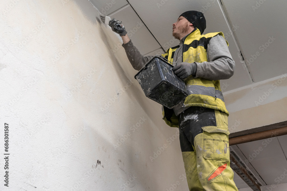 Skilled Craftsman Painting a Room in Fresh Overalls with Precision and Care. Skilled Craftsman Painting a Room in Fresh Overalls with Precision and Care.