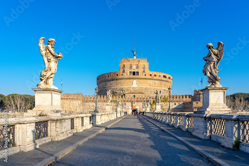Dome of the Castel Sant Angelo in Rome, seen through a bridge adorned by statues over the Tiber river. photo