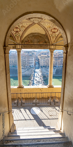 view of the bridge and the river Tiber through an arched balcony belonging to the castle of sant angelo in rome photo