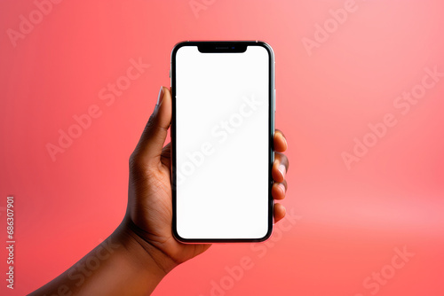 Close-up of a man's hand holding a smartphone with a white screen, a mockup on a pink background photo