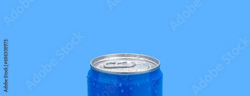 Aluminum jar with water drops on a blue background. A modern container for drinks. Copy space.
