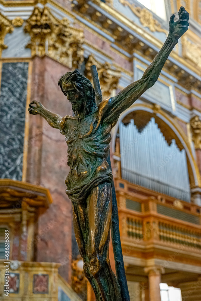Fototapeta premium statue of crucified jesus christ with the background of organ pipes inside the basilica SS Ambrogio e Carlo