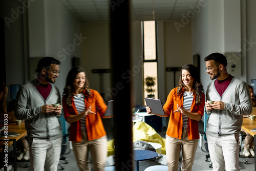 Young business couple standing with digital tablet in front of her team at the office