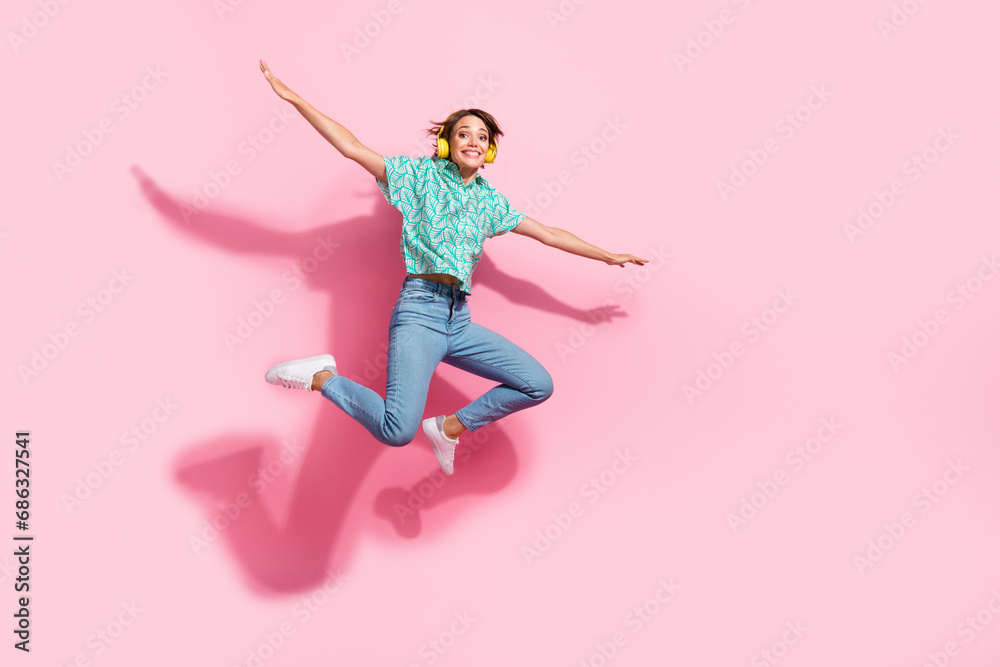 Full body photo of overjoyed excited lady jump arms wings fly empty space ad isolated on pink color background