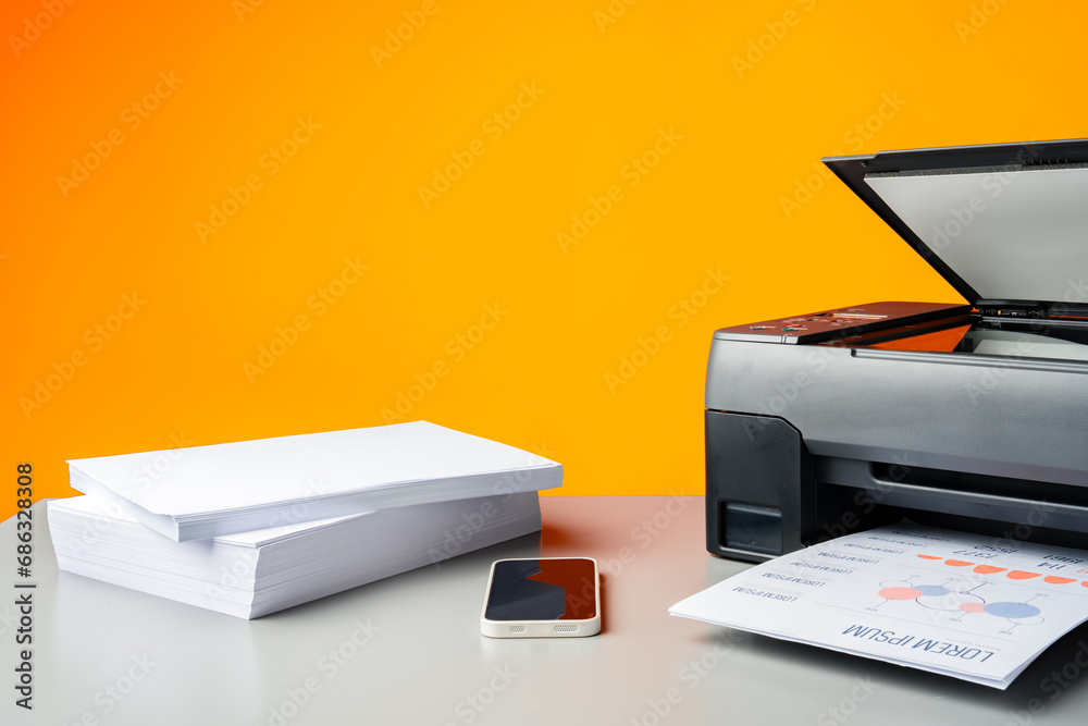 Laser printer on desk against yellow background. Laser printer on desk against yellow background.