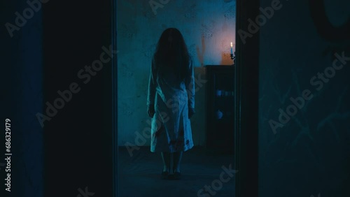 Possessed witch with long hair standing in haunted house room, evil spirit photo
