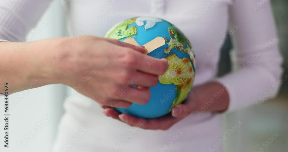Hand holding globe and adhesive patch Hand holding globe and adhesive patch
