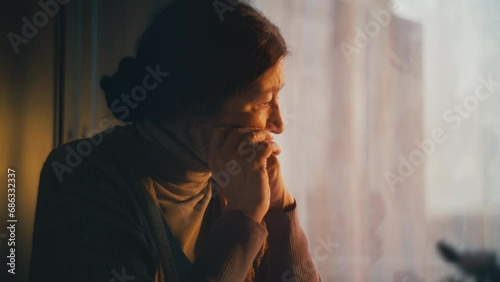 Sorrowful senior woman sitting alone, thinking about financial problems, poverty photo