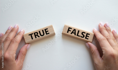 True or False symbol. Concept word True or False on wooden blocks. Businessman hand. Beautiful white background. Business and True or False concept. Copy space