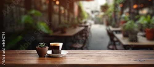 Use this image with a blurred coffee shop background and an empty brown wooden table for your photomontage or product display