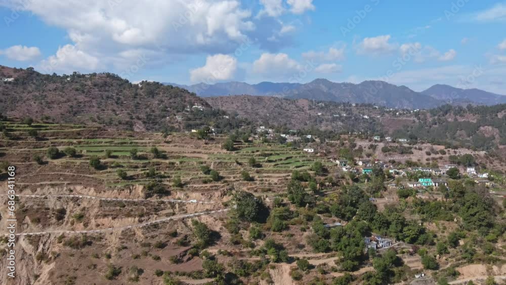 4K Aerial View of a Himalayan Valley Landscape in a Hilly Area with Green Surroundings and Blue Sky. Revealing Drone Shot of a Green Valley in Uttarakhand. 4K Aerial View of a Himalayan Valley Landscape in a Hilly Area with Green Surroundings and Blue Sky. Revealing Drone Shot of a Green Valley in Uttarakhand.