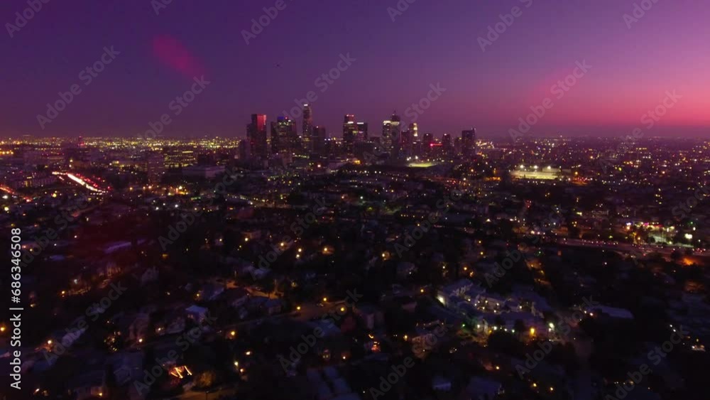 Aerial Forward Shot Of Modern Buildings In Financial District Amidst Residential City Against Dramatic Sky At Night - Los Angeles, California Aerial Forward Shot Of Modern Buildings In Financial District Amidst Residential City Against Dramatic Sky At Night - Los Angeles, California