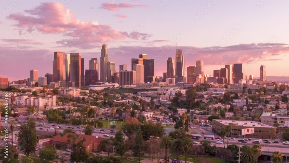 Aerial time lapse or hyperlapse of downtown Los Angeles, California skyline, skyscrapers and tall buildings from above on a sunny day during golden hour before sunset.