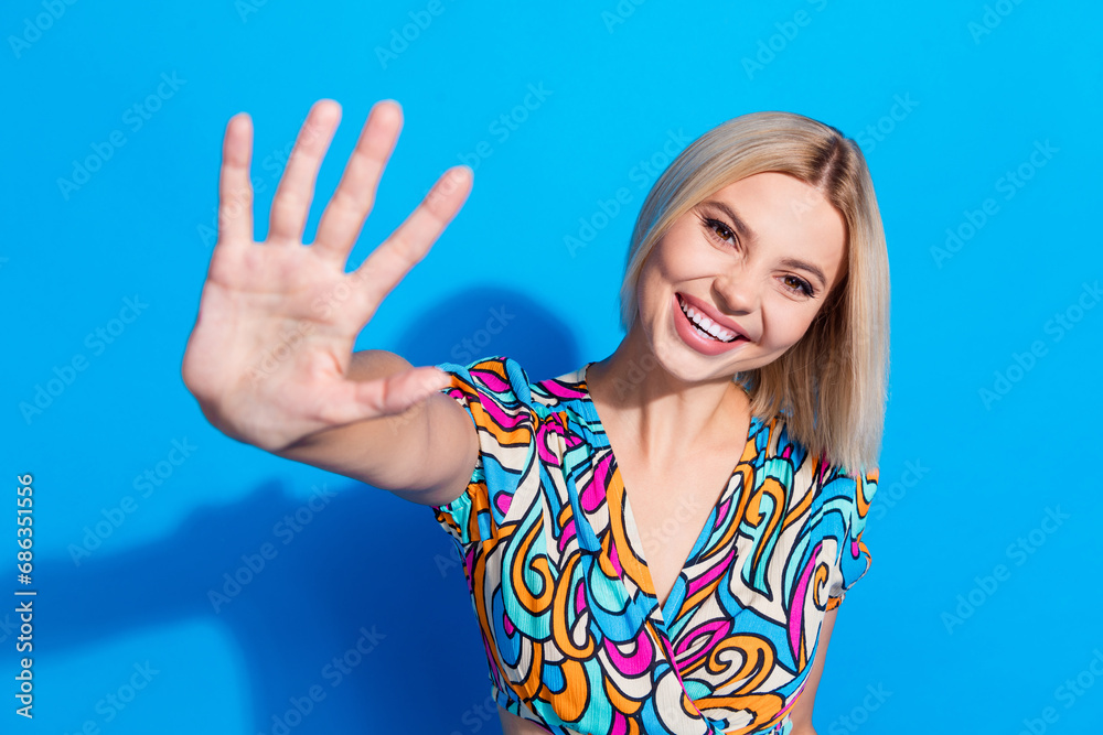 Fototapeta premium Portrait of positive nice lady toothy smile arm palm waving hi give high five isolated on blue color background