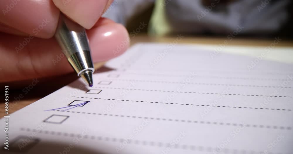 Closeup of hand putting checkmark or marking with blue pen on checklist and checkbox and to-do list