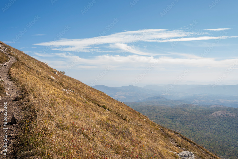 Sharp hill slope on Rtanj mountain with cloudy sky in the distance 