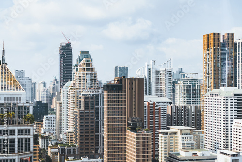 Closeup image of Bangkok cityscape. Modern cityscape surrounded with architectural building with day light and blue sky. Side view. Business background. Day light. Ornamented. © Summit Art Creations
