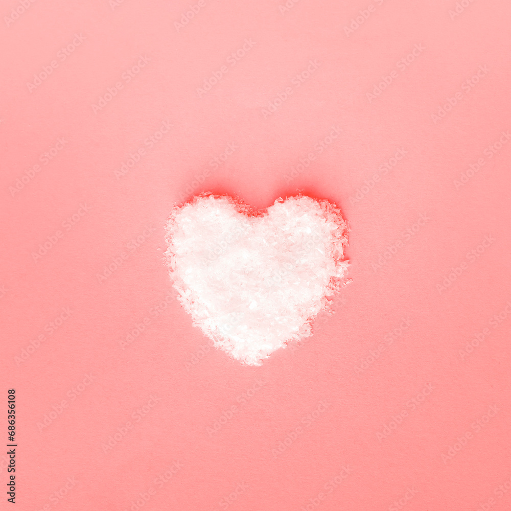 Heart made of snow on pink background. Valentines day concept. Top view, flat lay