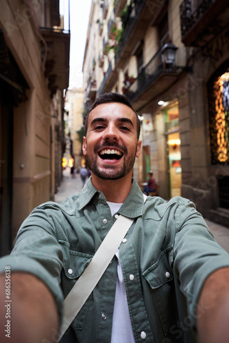 Obraz na plátně Happy vertical selfie of a young caucasian man in an old town of Barcelona