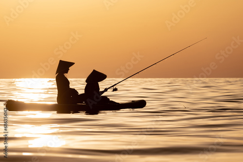 a woman with a child on a sup board in the sea swim against the background of a beautiful sunset, Standup paddleboarding