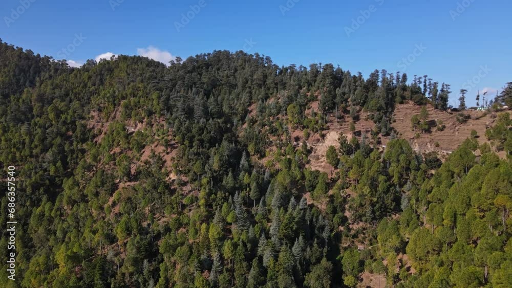 4K Aerial View of a Himalayan Valley Landscape in a Hilly Area with Green Surroundings and Blue Sky. Revealing Drone Shot of a Green Valley in Uttarakhand. 4K Aerial View of a Himalayan Valley Landscape in a Hilly Area with Green Surroundings and Blue Sky. Revealing Drone Shot of a Green Valley in Uttarakhand.