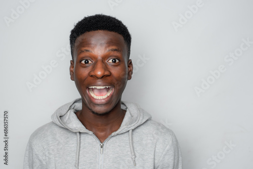 Happy cheerful young African gen Z isolated on white background. Funny smile teen student big surprise face