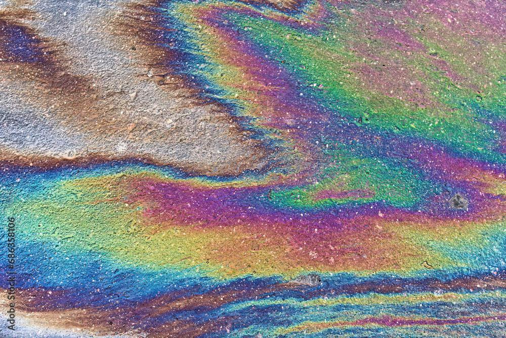 Background texture of oil spill on dark asphalt, parking lot