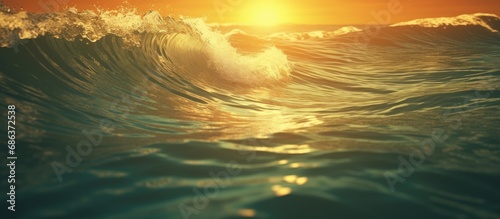 Rolling sea waves flowing gently turquoise colored against the background of the yellow glow of the sun