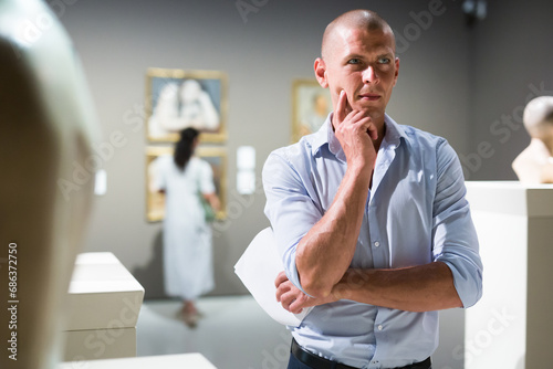 Middle aged man observing exhibits in museum