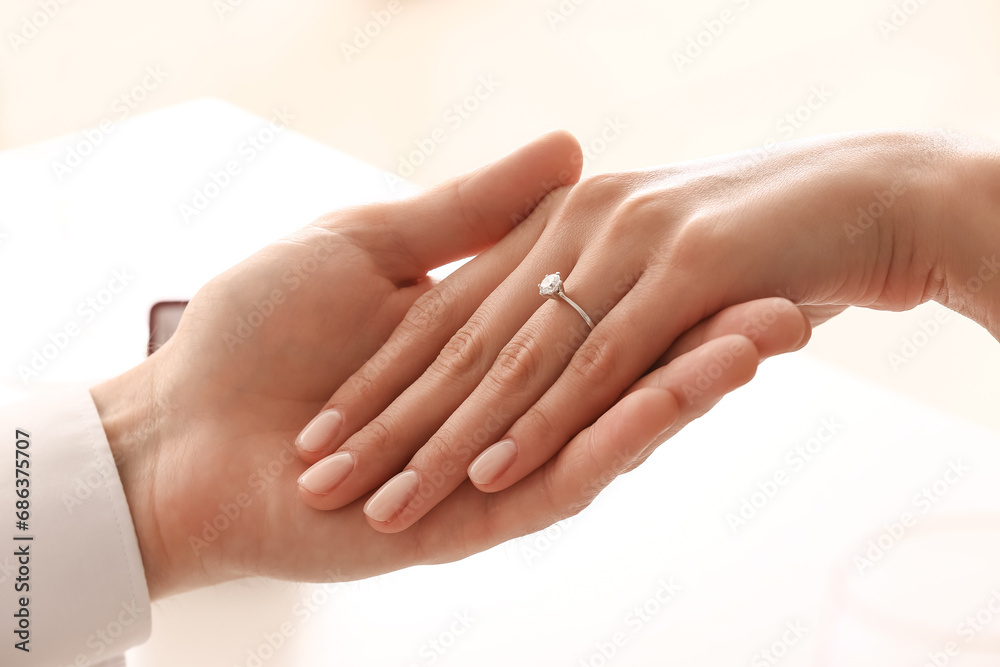 Engaged couple holding hands at table, closeup Engaged couple holding hands at table, closeup