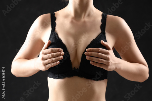 Young woman in bra on black...