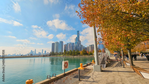 A beautiful autumn landscape on the banks of Lake Michigan at Navy Pier, autumn trees, people walking, skyscrapers, hotels and office buildings in the city skyline in Chicago Illinois USA