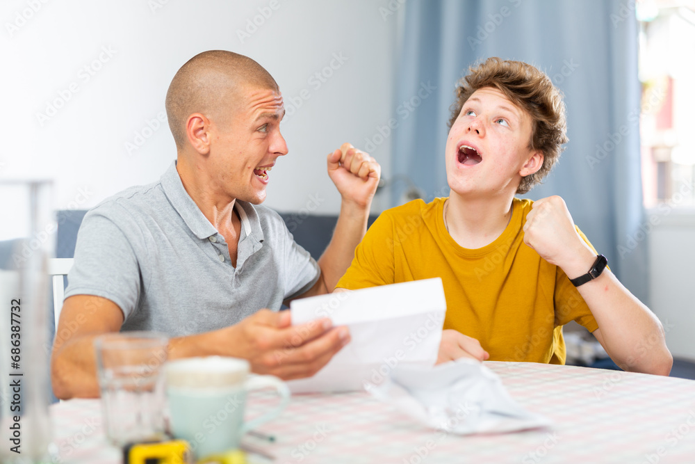 Father and son have recieved letter and reading it. They feeling happy because letter contains good news.