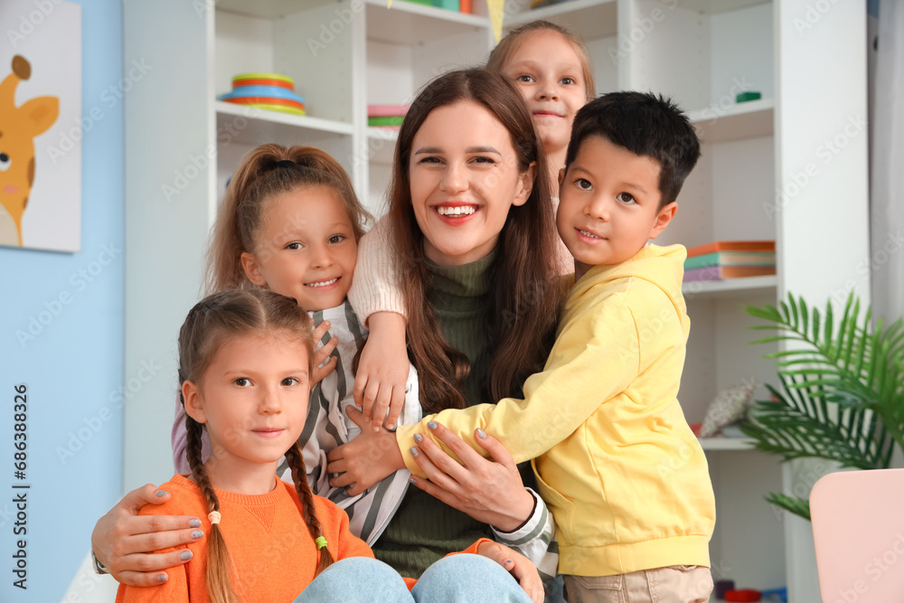 Little children with nursery teacher hugging in kindergarten Little children with nursery teacher hugging in kindergarten