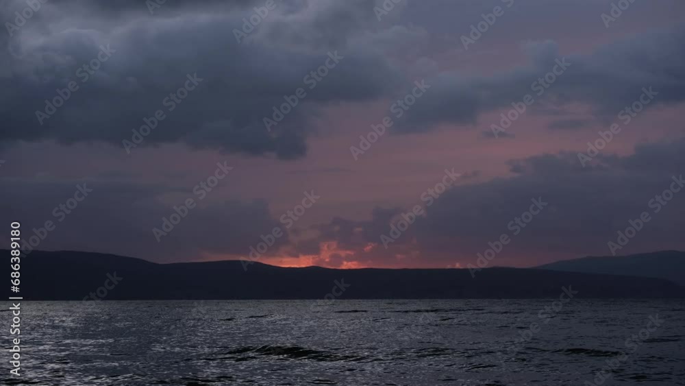 Fisherman in a fishing boat sailing on the sea. People at work concept. Fishing near the coast. Beautiful cloudy sunset. Calm ocean scenery with colourful sky and storm clouds in the background. Fisherman in a fishing boat sailing on the sea. People at work concept. Fishing near the coast. Beautiful cloudy sunset. Calm ocean scenery with colourful sky and storm clouds in the background.