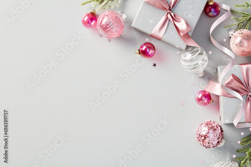 Christmas holiday grey background with chic gift boxes and pink ball decorations. Flat lay, top view.