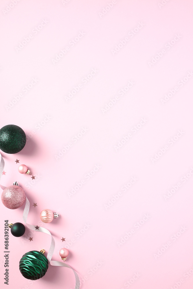 Vertical Christmas pink background with baubles, ribbon, and confetti. Flat lay, top view