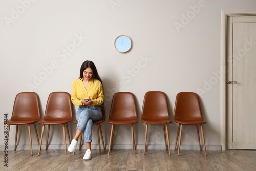 Young Asian woman with mobi...