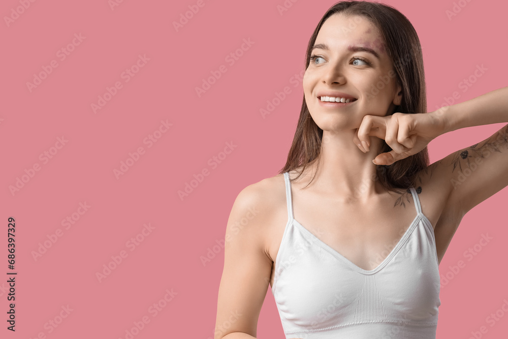 Young woman doing face building exercise on pink background Young woman doing face building exercise on pink background