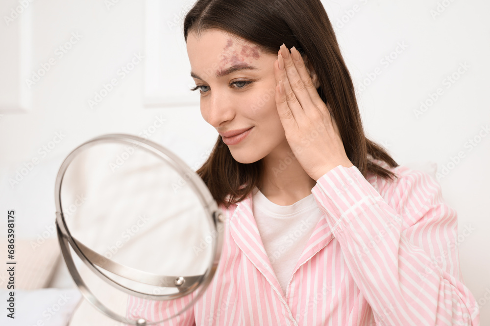 Young woman with mirror doing face building exercise in bedroom, closeup Young woman with mirror doing face building exercise in bedroom, closeup