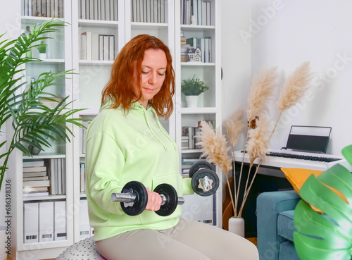 Obraz na płótnie woman doing sports exercises with fitness ball and dumbbells at home w salonie