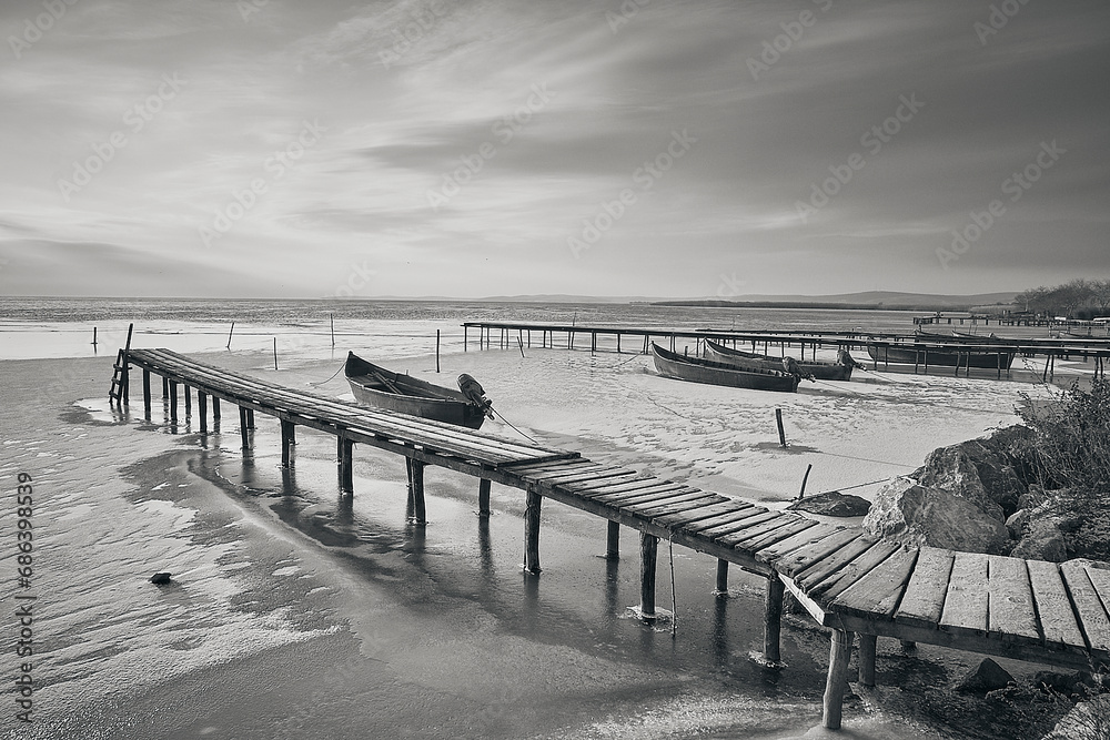 frozen boat in winter on the lake at sunrise
