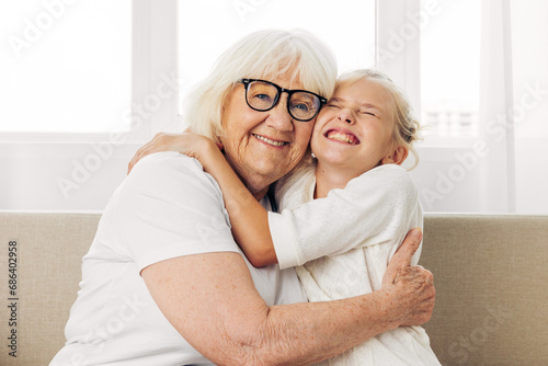 Girl hugging granddaughter child family grandmother couch home love sofa