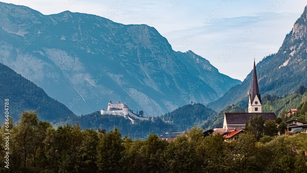 Alpine summer view with a church, Fortress Hohenwerfen and the Tennengebirge mountains near Pfarrwerfen, St. Johann im Pongau, Salzburg, Austria Alpine summer view with a church, Fortress Hohenwerfen and the Tennengebirge mountains near Pfarrwerfen, St. Johann im Pongau, Salzburg, Austria
