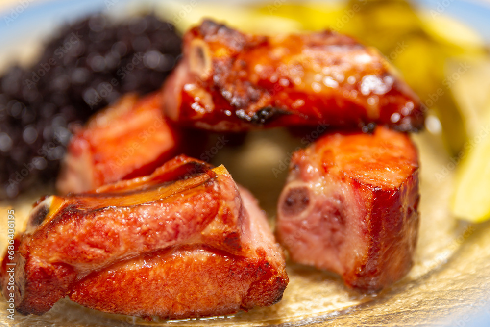 Traditional rustic Brazilian food, black rice, smoked pork ribs and pickles Traditional rustic Brazilian food, black rice, smoked pork ribs and pickles